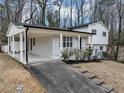 Charming two-story home featuring a light-colored exterior with a covered porch and a beautifully landscaped front yard at 847 Magna Carta Nw Dr, Atlanta, GA 30318