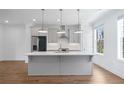 Bright, modern kitchen featuring stainless steel appliances, gray cabinets, and a central island at 102 Brackley Dr, Cumming, GA 30040