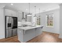Modern kitchen with stainless steel appliances, gray cabinets, island, and bright windows at 102 Brackley Dr, Cumming, GA 30040