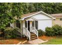 The exterior of a cozy white home with a manicured front yard and lush green foliage, nestled in a serene setting at 1947 Main St, Atlanta, GA 30318