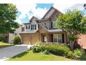 Charming two-story brick home featuring a two-car garage, landscaped yard, and covered front porch at 812 Autry Oak Ct, Alpharetta, GA 30022
