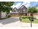 Two-story brick home with a two-car garage, a mailbox and landscaping at 812 Autry Oak Ct, Alpharetta, GA 30022