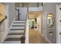 Light-filled home entryway featuring hardwood floors, elegant staircase, and views into the adjacent rooms at 1895 Henley Way, Alpharetta, GA 30009