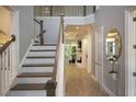 Bright foyer features hardwood floors, a staircase with white risers, and an elegant gold mirror at 1895 Henley Way, Alpharetta, GA 30009