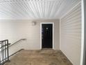A black front door on a porch with wood flooring, side rails and neutral siding at 3217 Fairington Dr, Lithonia, GA 30038