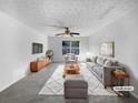 Bright living room features stylish furniture, a ceiling fan, and natural light from a large window at 3217 Fairington Dr, Lithonia, GA 30038
