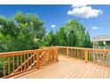 Spacious wooden deck offering a relaxing outdoor space surrounded by lush green trees and blue skies at 522 Spring View Dr, Woodstock, GA 30188