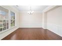 Bright dining room with hardwood floors, decorative molding, a modern chandelier, and a large window at 522 Spring View Dr, Woodstock, GA 30188