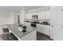 Well-lit kitchen with granite countertops, stainless steel appliances, and white cabinets at 7801 Sudbury Cir, Covington, GA 30014