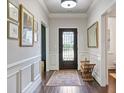 Elegant entryway with hardwood floors, wainscoting, decorative mirror, and a stylish front door at 452 Rockford Pass, Marietta, GA 30064