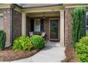 Inviting front porch with brick accents, a seating area, and a decorative front door at 452 Rockford Pass, Marietta, GA 30064