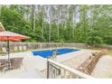 Sparkling blue pool surrounded by a fenced-in yard, ideal for summer fun and relaxation at 1667 Quail Run, Conyers, GA 30094