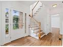 Bright foyer with hardwood floors, a staircase with white railings, and a front door with glass panels at 1711 Summit Glen Ln, Atlanta, GA 30329