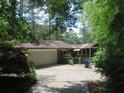 Back of brick home with attached garage, screened porch, and mature landscaping at 2448 Sherbrooke Ne Ct, Atlanta, GA 30345
