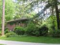 Brick home with mature landscaping in a wooded setting has a charming aesthetic at 2448 Sherbrooke Ne Ct, Atlanta, GA 30345