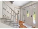 Inviting foyer with hardwood floors, a carpeted staircase, and an ornate front door with sidelights at 5236 Forest Brook Pkwy, Marietta, GA 30068