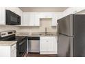 Modern kitchen featuring stainless steel appliances, granite countertops, and sleek white cabinetry at 793 Springdale Sw, Atlanta, GA 30315