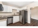 Bright kitchen with stainless steel appliances, granite counters, white cabinets, and dark hardwood floors at 793 Springdale Sw, Atlanta, GA 30315