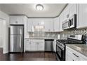 Modern kitchen featuring white cabinetry, stainless steel appliances, and a stylish backsplash at 374 Lamancha Ct, Lawrenceville, GA 30044