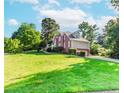 Expansive two-story brick home with a lush lawn, mature trees and attached two-car garage at 1100 Midland Way, Lawrenceville, GA 30043