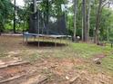 The backyard shows a trampoline nestled between trees and underbrush at 3293 Oakcliff Rd, Doraville, GA 30340