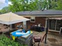 Untidy backyard with an umbrella, random furniture, and grilling equipment on a concrete pad at 3293 Oakcliff Rd, Doraville, GA 30340