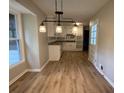 Open dining area with modern lighting fixtures and hardwood floors overlooking the kitchen at 420 Creekview Ct, Marietta, GA 30064