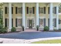 Detailed view of home's entrance featuring classic columns and black shutters and flower planter decoration at 575 Valley Hall Dr, Sandy Springs, GA 30350