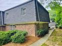 Brick townhome with a well-manicured lawn and beautiful landscaping surrounding the property at 1128 Hampton Way, Atlanta, GA 30324