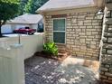 Back patio features stone, a brick walkway, and a stone wall, surrounded by greenery at 302 Gladstone Dr, Mcdonough, GA 30253