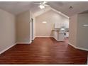 Open concept living and dining area featuring a vaulted ceiling and laminate flooring at 302 Gladstone Dr, Mcdonough, GA 30253