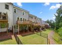 Backyard features a well-manicured lawn, fenced yard, and elevated patio at 402 Retreat Ln, Canton, GA 30114