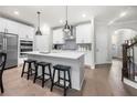 Modern white kitchen features a large island, stainless steel appliances, and sleek pendant lighting at 402 Retreat Ln, Canton, GA 30114