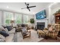 Bright living room with a cozy fireplace, ceiling fan, and large windows with stylish shutters at 402 Retreat Ln, Canton, GA 30114