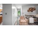 Hallway with modern decor, leading to the front door with a chair and white shelving unit at 6487 Northridge Way, Morrow, GA 30260