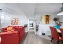 View of a living room with a red sofa, dining area, and hallway leading to other rooms at 6487 Northridge Way, Morrow, GA 30260