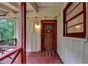 Close-up of a quaint front porch featuring a rustic wooden door and traditional design at 8805 Lake Dr, Snellville, GA 30039