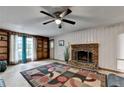 Cozy living room with a brick fireplace, built-in shelving, and a decorative ceiling fan at 8805 Lake Dr, Snellville, GA 30039