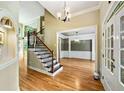 Elegant foyer showcasing hardwood floors, staircase with iron spindles, and views into the dining room at 205 Camden Creek Ct, Lawrenceville, GA 30043