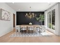 Modern dining room featuring a unique table, designer chandelier, and views from the large windows at 2297 Nesbitt Ne Dr, Brookhaven, GA 30319