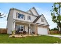 Attractive two-story home with stone accents, a welcoming front porch, and professionally landscaped front yard at 437 Autrey Dr, Douglasville, GA 30134