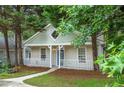 Charming bungalow features a quaint front porch, fresh paint, and mature trees at 4594 Poplar Rd, Pine Lake, GA 30072