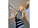 Stunning two-story foyer featuring a staircase with black iron railings and wood flooring at 5688 Baffin Rd, Atlanta, GA 30349