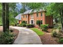 Lovely brick home showcasing a well-maintained lawn, mature trees, and a winding driveway for added curb appeal at 1320 Northcliff Trce, Roswell, GA 30076