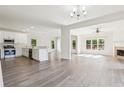 Bright open-concept living space features wood floors, fireplace, recessed lighting, and seamless flow to dining and kitchen at 296 Water Oak Pl, Alpharetta, GA 30009