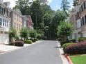 A view of homes lining a street, with mature trees and shrubs and well-maintained curbsides at 2975 Wintercrest Trce, Dunwoody, GA 30360