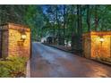 Grand stone gated entrance with lanterns illuminating the driveway to the home at 1500 Historic Vw, Stone Mountain, GA 30087