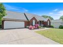 Charming brick home features a two-car garage, well-manicured lawn, and colorful flower beds at 20 Friendship Rd, Euharlee, GA 30145