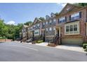 Beautiful townhome exteriors with brick accents, driveways, and street parking with tree line in the background at 2774 Birch Grove Se Ln # 11, Marietta, GA 30067