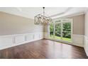 Bright dining room with hardwood floors, elegant trim, and large windows overlooking the yard at 4685 Braselton Hwy, Hoschton, GA 30548